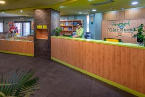 a lobby with a counter with people standing behind it at Vilar Rural De Sant Hilari Sacalm by Serhs Hotels in Sant Hilari Sacalm