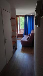 a living room with a couch in front of a window at Residence Les Ecrins in Puy-Saint-Vincent