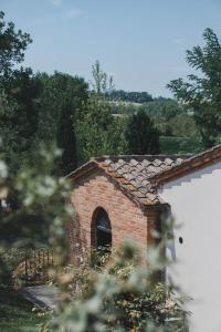 un edificio de ladrillo con techo y ventana en Borgo San Vincenzo, en Montepulciano