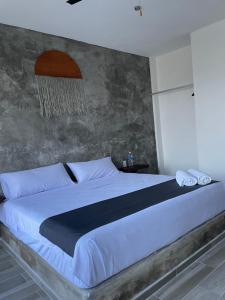 a bedroom with a large bed with two white pillows at Lunazul Hotel By Rotamundos in La Vigueta
