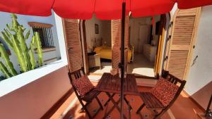 zwei Stühle auf einem Balkon unter einem Sonnenschirm in der Unterkunft Loma del Rey 56 - casa primera linea de mar in Alcaidesa