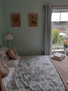 Un dormitorio con una cama grande y una ventana en Rose Cottage, en Telford
