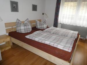 Un dormitorio con una cama con almohadas a cuadros. en Ferien und Selbstversorgerhaus für Gruppen Sauerthaler Hof - Loreley, en Sauerthal