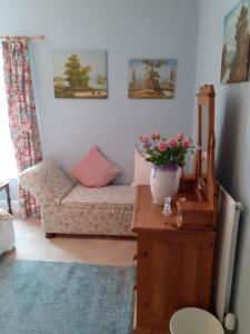 ein Wohnzimmer mit einem Sofa und einer Vase aus Blumen in der Unterkunft Rose Cottage in Telford + 6 Fotos