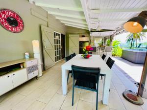 a dining room with a white table and chairs at Jolie petite Villa sur une presqu’île in Le Gosier +64 photos