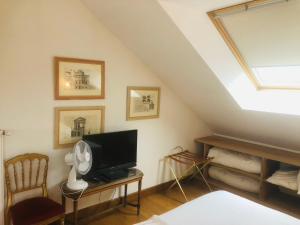 a room with a bed and a tv and a window at L'Orangerie "The Orangery" du parc des Nouies in Selles-sur-Cher