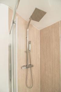 a shower with a shower head hanging from a ceiling at JOIVY Family house with courtyard in Hoylake in Hoylake
