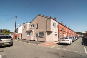 uma rua com carros estacionados em frente a um edifício em JOIVY Family house with courtyard in Hoylake em Hoylake