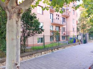 a tree on the side of a sidewalk next to a building at JAY's Park Place in Cluj-Napoca