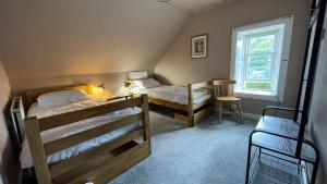 莫法特的住宿－Moffat Independent Hostel，一间卧室设有两张双层床和一扇窗户。