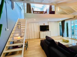 een woonkamer met een trap naar een loft bij Jolie petite Villa sur une presqu’île in Le Gosier