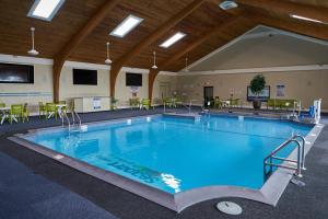 a large swimming pool in a room with tables and chairs at Seaport Resort and Marina in Fairhaven