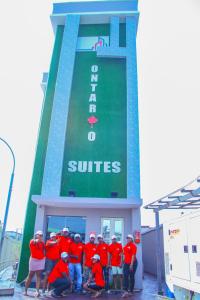 a group of men in red shirts standing in front of a building at ONTARIO SUITES in Lagos