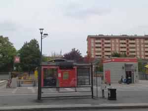 uma paragem de autocarro com um vermelho numa cidade em Inna Best House em Milão