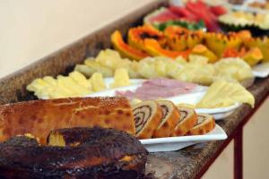 ein Buffet mit verschiedenen Speisen auf dem Tisch in der Unterkunft Pousada Coqueiro Verde in Japaratinga