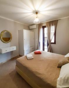 een slaapkamer met een groot bed en een raam bij Vacations in Corfu-Antiperni by CorfuEscapes in Antipernoí
