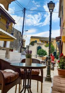een patio met een tafel en stoelen en een straatlicht bij Vacations in Corfu-Antiperni by CorfuEscapes in Antipernoí