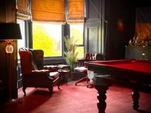 a room with a pool table and chairs and a window at Moffat Independent Hostel in Moffat