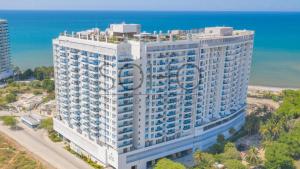 einem Luftblick auf ein großes weißes Gebäude in der Nähe des Ozeans in der Unterkunft Apartamentos Reserva del Mar - Frente al Mar by SOHO in Santa Marta