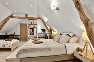 a bedroom with a large bed in a attic at Ferme des Petites Oreilles 4 étoiles in Montignac