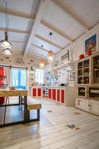 une cuisine avec des placards rouges et blancs et une table en bois dans l'établissement La Casa di Nonna Piera, à Giardini Naxos