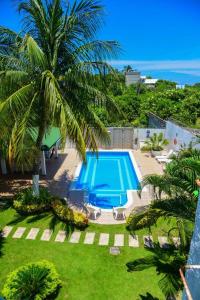 una piscina con una palmera junto a un complejo en VG Villa Gloria, en Santa Marta