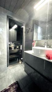 盧卡的住宿－Ruka Chalet Petit Oliver，浴室配有盥洗盆、镜子和浴缸
