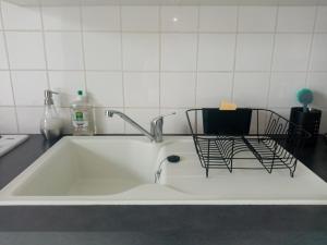 un grande lavandino bianco con rubinetto in cucina di Quiétude et confort a Tallard