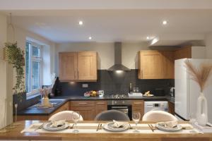 曼徹斯特的住宿－Bee Stays - Byron House，厨房配有木制橱柜和白色冰箱。