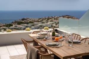 drewniany stół z kieliszkami do wina i pomarańczami na balkonie w obiekcie Infinity Horizon Apartment - Costa Blanca w mieście Cumbre del Sol