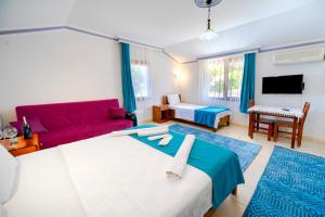 a living room with a large bed and a red couch at Flower Hotel Patara in Patara