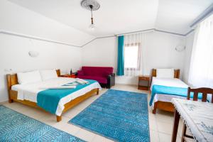 um quarto com 2 camas e um sofá vermelho em Flower Hotel Patara em Patara