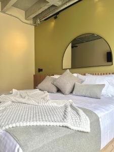 a large white bed with a large mirror on the wall at beminimal parques in Medellín +109 photos