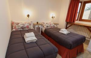 sypialnia z 2 łóżkami i ręcznikami w obiekcie Isla Bonita Suites w mieście Ushuaia