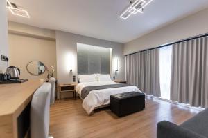 a hotel room with a bed and a desk and a room at Ethereal Athεns in Athens