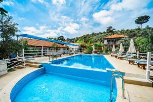 a pool at a resort with tables and chairs at Flower Hotel Patara in Patara