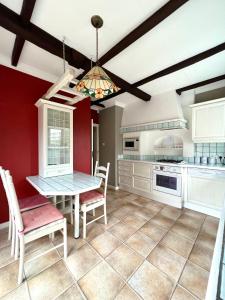 een keuken met witte kasten en een tafel en stoelen bij 19A Stourwood Avenue in Southbourne