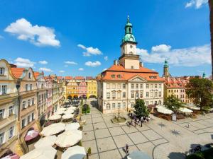 un vieux bâtiment avec une tour d'horloge dans une ville dans l'établissement Ratusz na 5, à Jelenia Góra