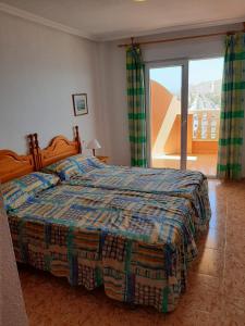 a bedroom with a bed and a large window at Apartamentos Turísticos Isla Grosa in La Manga del Mar Menor