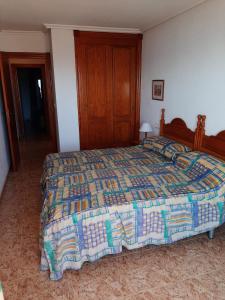 1 dormitorio con 1 cama con colcha colorida en Apartamentos Turísticos Isla Grosa, en La Manga del Mar Menor