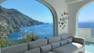 a living room with a couch and a view of the ocean at Villa sul mare - Praiano (Amalfi Coast) in Praiano