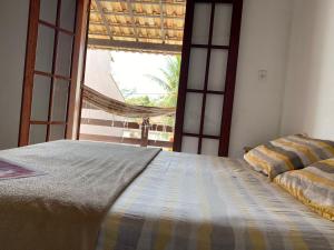 a bedroom with a bed and a large window at Pousada do Foguete in Cabo Frio