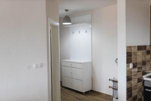 a kitchen with a white cabinet and a white wall at Class Apartment in Brčko