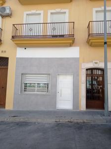 ein Gebäude mit einer weißen Tür und einem Balkon in der Unterkunft El Rincón de Paula in Baena