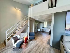 a living room with a staircase and two chairs at Hotel Estelou in Sommières