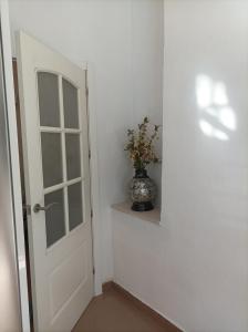 ein Zimmer mit einer Vase auf einem Regal neben einer Tür in der Unterkunft El Rincón de Paula in Baena