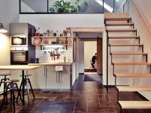 a room with a staircase and a kitchen with a table at Madaras Házak in Cserhátszentiván