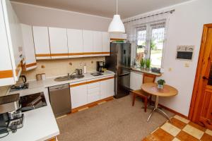 uma cozinha com armários brancos e uma mesa de madeira em Domek na skarpie em Rybno