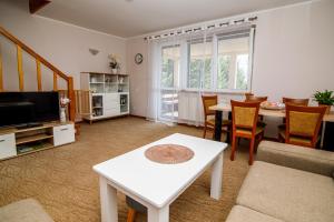 uma sala de estar com uma mesa e uma sala de jantar em Domek na skarpie em Rybno