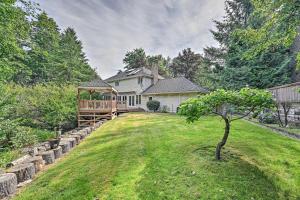 una casa con un patio con un árbol delante en Family-Friendly Redmond Home with Spacious Deck en Redmond